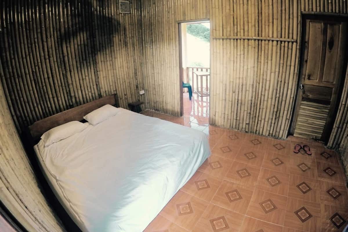 Een kamer met een bed, een deur en een vloer met een patroon.