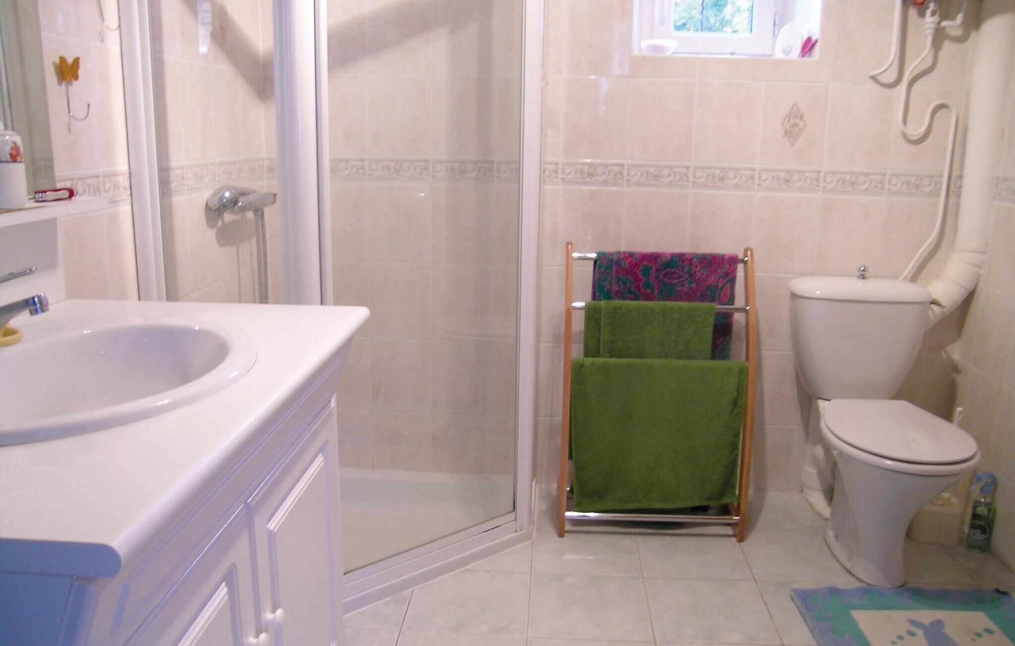 A bathroom with a shower, toilet, and sink.