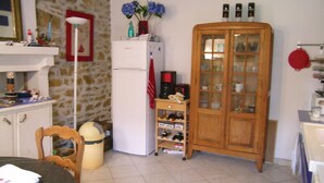 A kitchen with a white refrigerator, wooden cabinet, and a coffee maker on a small table. - Awesome home in Pleumeur Gautier (Pleumeur Gautier)