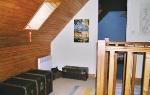 Cozy retreat with sloped ceiling, wooden paneling, and a staircase to a loft area.