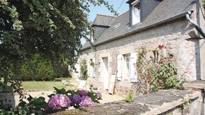 A stone building with a garden in front, featuring hydrangeas and a wooden bench. - Awesome home in Pleumeur Gautier (Pleumeur Gautier)