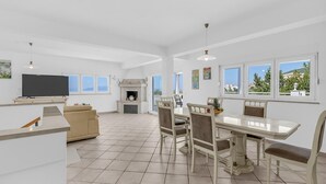 A spacious living area with a TV, sofa, dining table, chairs, and a fireplace. - Beautiful home in Makarska with WiFi (Makarska)
