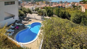 A swimming pool with lounge chairs, surrounded by greenery and overlooking a coastal town. - Beautiful home in Makarska with WiFi (Makarska)
