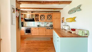 Eine Küche mit Holzschränken, einem Herd, einer Spüle und einer Arbeitsplatte mit einem Toaster und einer Tüte Lebensmittel.