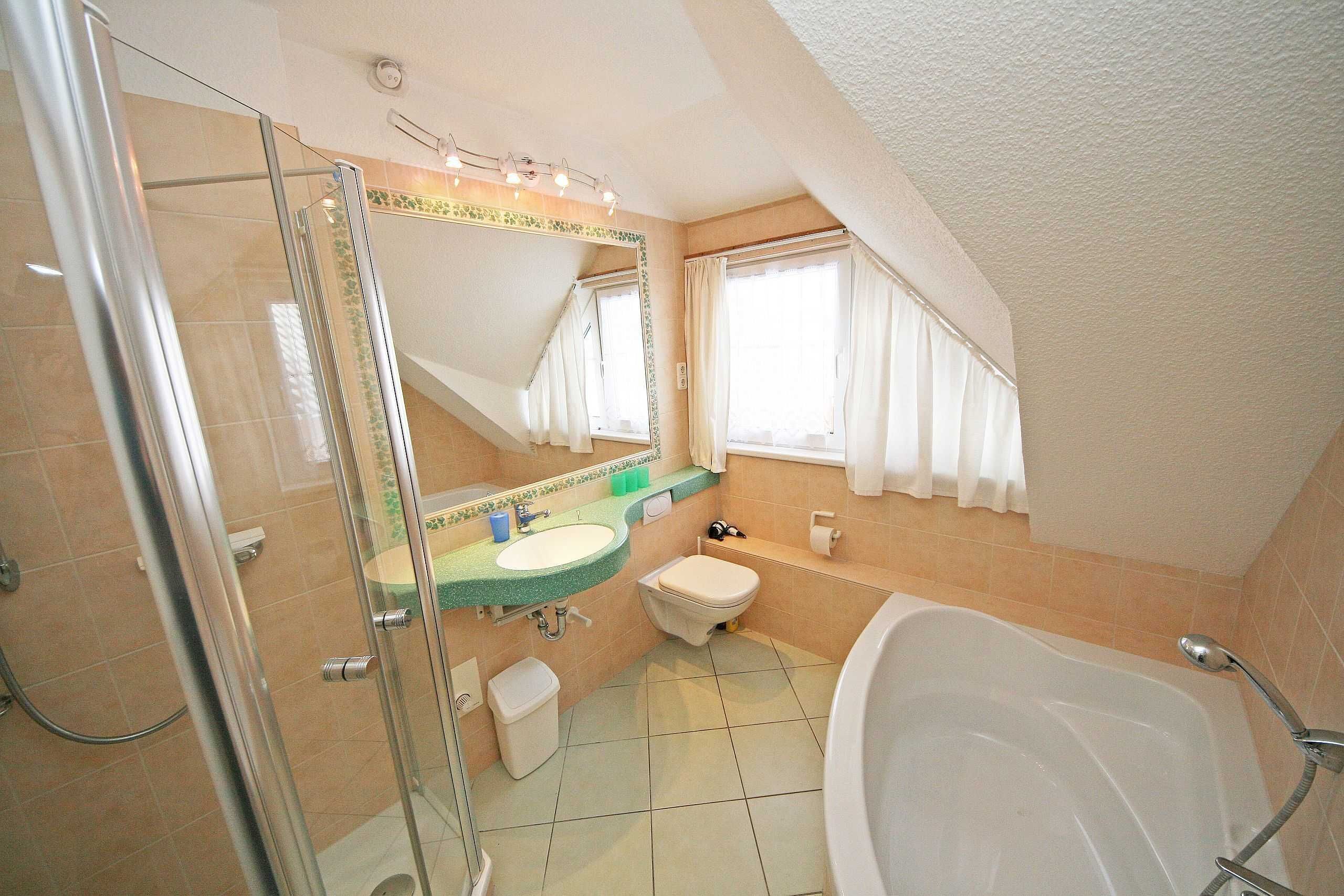 A bathroom with a glass shower enclosure, a sink, a toilet, and a bathtub.