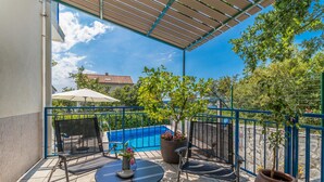 A balcony with a pool, outdoor furniture, and potted plants. - Gorgeous home in Jadranovo (Jadranovo)