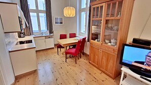 Ein kompakter Wohnbereich mit Küchenzeile, Essplatz und Fernseher.
