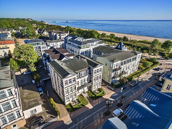 A residential area with a beach and pier in the background.
