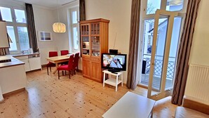Eine moderne Wohnung mit Essbereich, Küche und einem Balkon mit großen Fenstern.