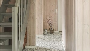A narrow hallway with wooden walls and patterned floor tiles. - Awesome home in Hebnes with house sea view (Hebnes)