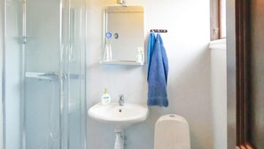 A bathroom with a glass shower enclosure, a white sink, a mirror, and a blue towel hanging on a rack. - 2 bedroom cozy home in Mörbylånga (Mörbylånga)