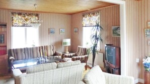 A living room with striped wallpaper, a sofa, armchairs, a glass coffee table, a lamp, a TV, and a plant. - 2 bedroom cozy home in Mörbylånga (Mörbylånga)