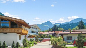 A residential area with houses featuring balconies and a mountain backdrop.