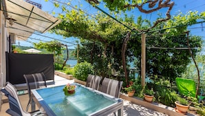 An outdoor patio with a glass-top table, chairs, and potted plants. - 3 bedroom amazing home in Trget (Trget)