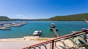 A marina with various boats docked, a small boat near the dock, and a hilly landscape in the background. - 3 bedroom amazing home in Trget (Trget)
