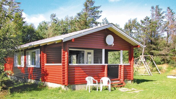 A small, red wooden cabin with a porch, a satellite dish, and a number '63' on the door. - 2 bedroom cozy home in Rømø (Rømø)
