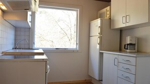 A compact kitchen with a window, a sink, a refrigerator, a coffee maker, and cabinets. - 2 bedroom cozy home in Rømø (Rømø)