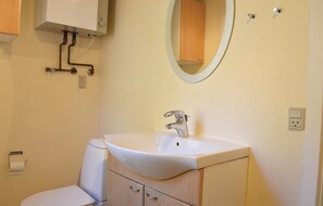 Ein Badezimmer mit Waschbecken, Spiegel und Toilette.