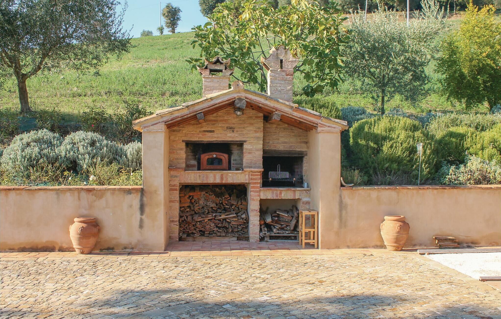 A rustic stone building with a chimney, a small wooden door, and a brick fireplace.