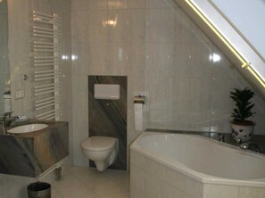 A bathroom with a bathtub, toilet, and sink.