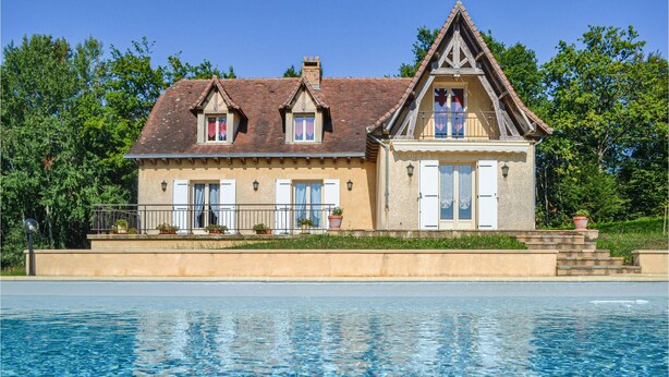Une maison à deux étages avec une piscine à l’avant.