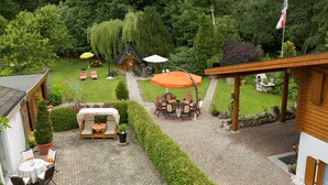 Un espace extérieur aménagé avec une table et des chaises, un petit jardin et une structure en bois.