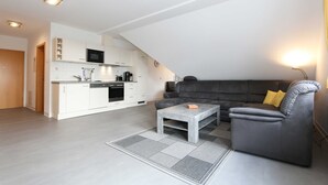 Un apartamento moderno con cocina, sala de estar y un sofá.