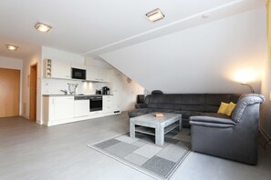 A modern apartment with a kitchen, living area, and a sofa.