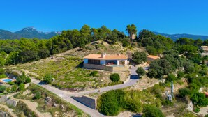 A hillside villa with a stone exterior, a tiled roof, and a swimming pool. - Stunning home in Galilea (Galilea)