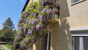 Una casa con porche cubierto, escaleras y jardín.