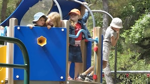Un parque infantil con un tobogán azul y estructuras para escalar.