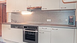 Eine Küche mit Geschirrspüler, Backofen und einer Arbeitsplatte aus Granit.