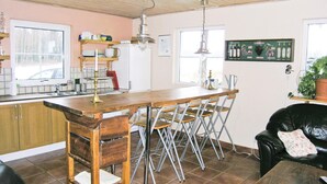 A kitchen with a wooden bar, metal chairs, a sink, and a refrigerator. - Amazing home in Ljungsarp with sauna (Ljungsarp)