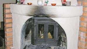 A brick oven with a white exterior and a shelf above it holding small decorative items. - Amazing home in Ljungsarp with sauna (Ljungsarp)