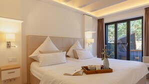 A hotel room with a bed, bedside table, lamp, and a view of the outdoors. - Nice apartment in Binz with outdoor swimming pool (Prora/Rügen)