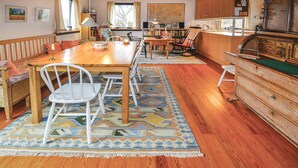 A cozy, well-lit dining area with a wooden table, white chairs, and a colorful rug. - Amazing home in Askeby with kitchen (Askeby)