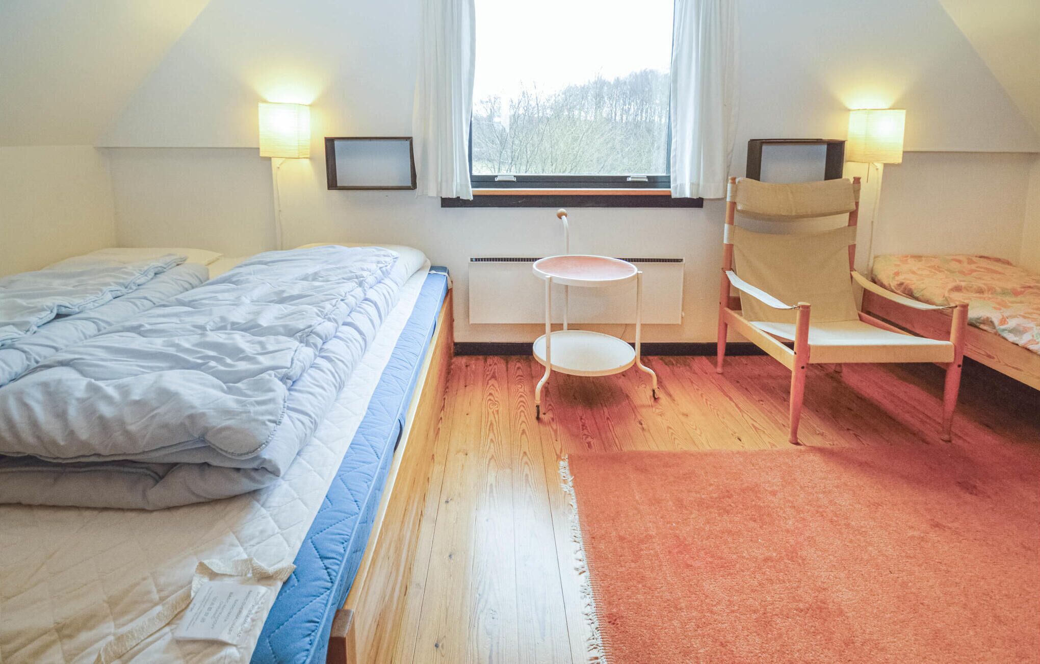 A bedroom with two beds, a small table, and two chairs.