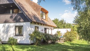 A traditional house with a steeply pitched roof, white exterior walls, and a small window. - Amazing home in Askeby with kitchen (Askeby)