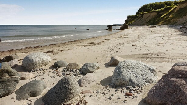 A sandy beach with large rocks and a cliff. - Amazing home in Askeby with kitchen (Askeby)