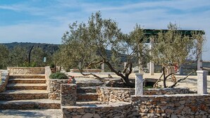 A stone pathway leading to a stone structure with olive trees. - Gorgeous home in Povlja (Povlja)
