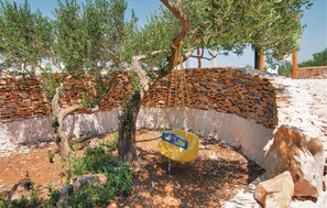 Relax in a serene outdoor setting surrounded by nature, complete with a shaded area and a charming swing.