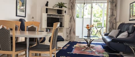 Ein modernes Wohnzimmer mit Esstisch, Stühlen, einer Couch und einem Couchtisch.
