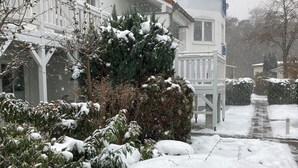 Un quartier résidentiel enneigé, avec des maisons, un chemin et une clôture blanche.