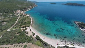 An aerial view of a coastal area with a beach, clear blue waters, and surrounding greenery. - Beautiful home in Prizba with kitchen (Prizba)