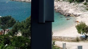 Blick auf die Küste mit Gebäuden, einem Strand und einem klaren Himmel.