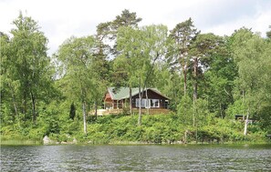 A cabin surrounded by dense forest, with a lake in the foreground. - Lovely home in Skånes Fagerhult (Skånes Fagerhult)