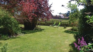 A well-maintained garden with a lawn, a wooden fence, and a variety of plants and flowers. - 3 bedroom cozy home in Frise (Frise)