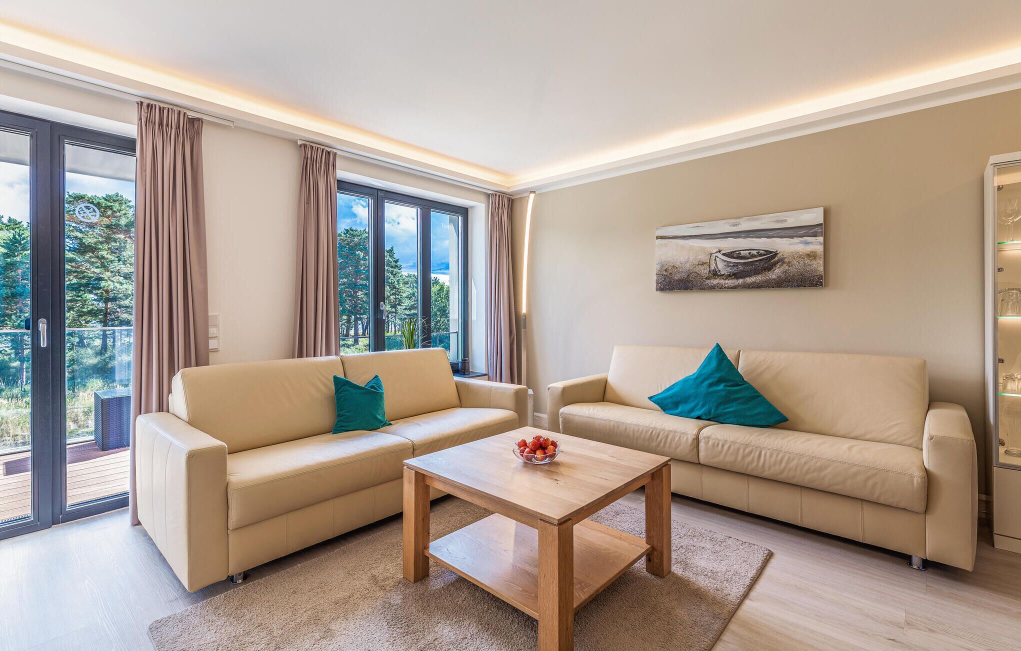 Ein modernes Wohnzimmer mit zwei beigefarbenen Sofas, einem Holztisch und einem Bild an der Wand.