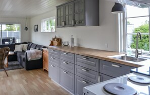 A modern kitchen with grey cabinets, a wooden countertop, and a built-in stove. - Nice home in Hadsund with WiFi (Hadsund)