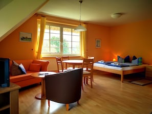 Una habitación acogedora con cama, sofá, mesa de comedor y sillas.